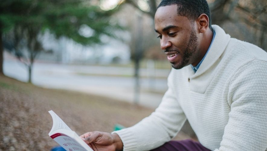 Wellbeing books: Black man reading a book