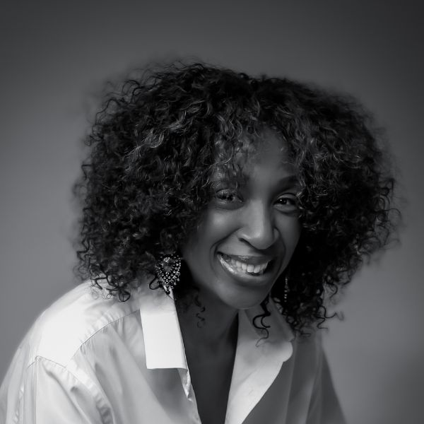 Headshot image of a person sitting down and smiling into the camera